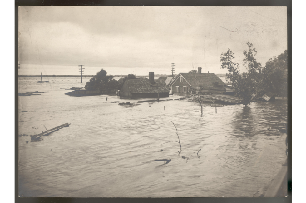Black and white photographic print showing houses submerged along Salt Creek in Lincoln,...