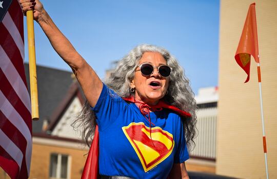 A woman holds an American flag outside the Nebraska State Capitol on Saturday, Oct. 18, 2025,...